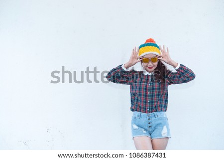 Asian hipsters girl posing for take a photo on white wall,lifestyle of modern woman wear short denim,Thai people in hippie style,sweet lady act for photo shoot outdoor