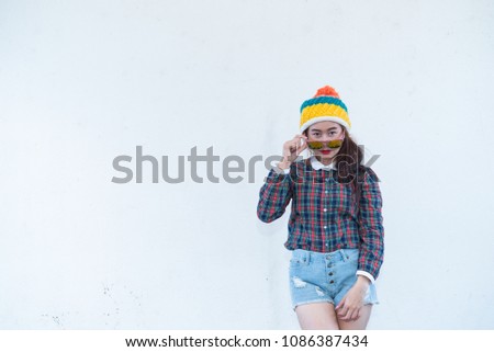 Asian hipsters girl posing for take a photo on white wall,lifestyle of modern woman wear short denim,Thai people in hippie style,sweet lady act for photo shoot outdoor