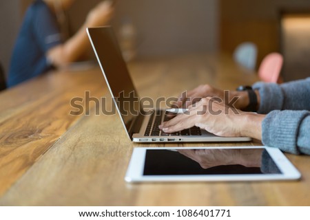 close up designer man hand using laptop and typing for working program or searching information on internet at modern loft office concept