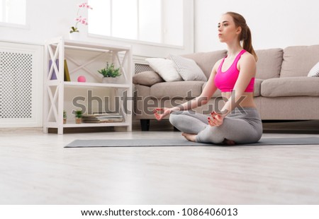 Fitness, woman yoga relax meditation in lotus pose at home. Young slim girl makes exercise, copy space.