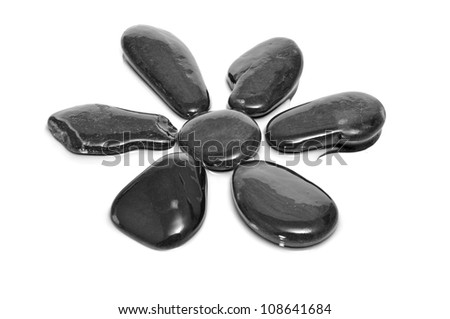 some black stones forming a flower on a white background