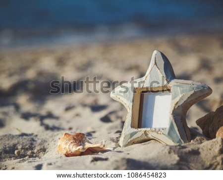 Blank empty photo frame with copy space at the sandy beach