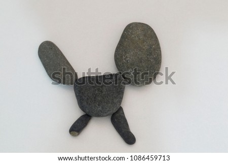 kid's activities with stones on the white background in the school. making dog picture. 