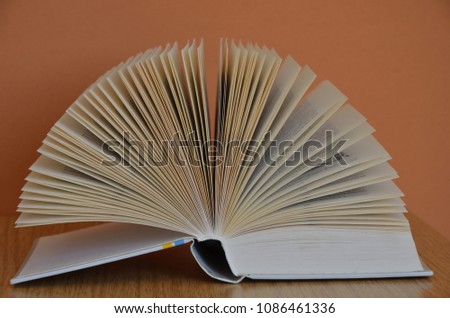 Open Book forming a fan on wooden Table