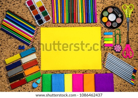 

The yellow sheet of paper over school and office supplies on office table. Top view with copy space. Back to school 