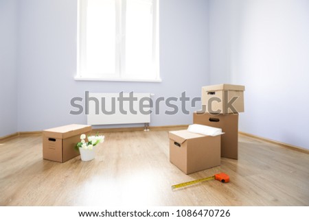 Cardboard boxes on laminate floor in empty room. Preparation for movement to new apartment. Nobody
