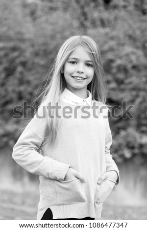 Beauty, youth, growth. Girl with blond long hair smile on natural landscape. Happy childhood concept. Child in grey sweater on idyllic autumn day. Kid fashion and style.