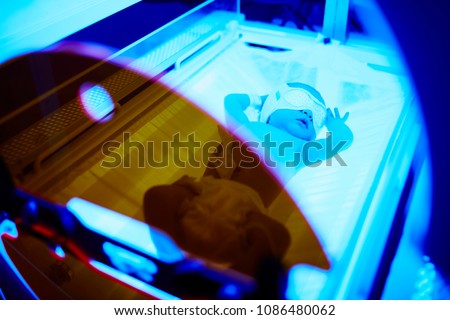 Newborn baby girl receiving phototherapy for jaundice at the maternity hospital Royalty-Free Stock Photo #1086480062