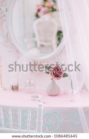 Dressing table. Care products on a table. A rose flower in a vase.