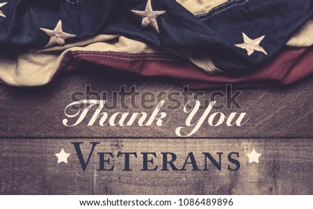 A vintage American flag or bunting on a wooden background with Veteran's day greeting