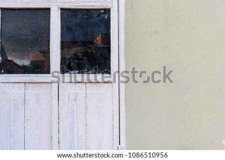White window on a beige background with refections on the glass