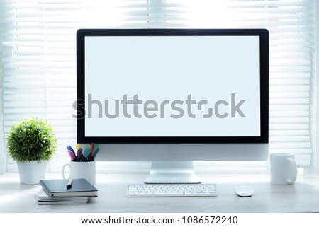 Stylish workspace with computer and mockup poster on home or studio. Royalty-Free Stock Photo #1086572240