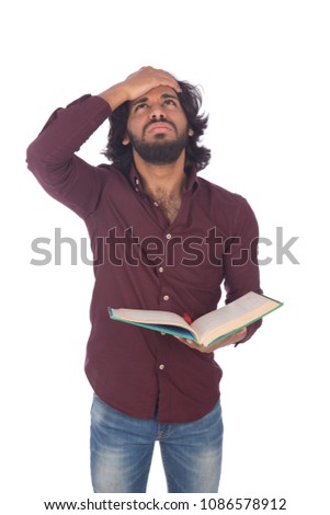 Young student holding an open book looks exhausted putting a hand on the forehead surprised, isolated on a white background.