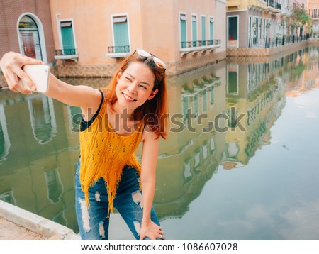 Asian woman tourist is taking selfie photo from the smartphone.