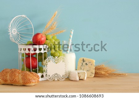 image of fruits, bread and cheese in decorative basket over wooden table