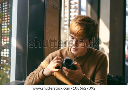 Asian guy takes photo with camera