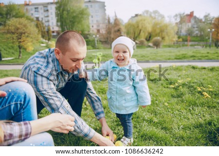 Beautiful mom with her husband and their little daughter in the spring park