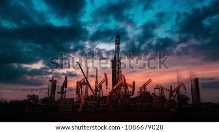 Oil Drilling Rig with group of oil pump or jackpump or Donkey pump with twilight beautiful sky