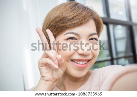 Pretty asian short hair woman take a self portrait with her smart phone Asian girl selfie, isolated on white background
