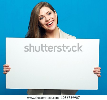 Smiling woman holding white billboard for advertising sign. Blue background.