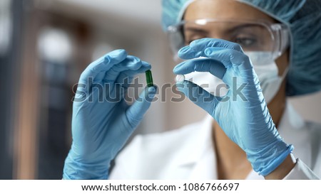 Pharmacology expert comparing two pills, analyzing medical research results Royalty-Free Stock Photo #1086766697