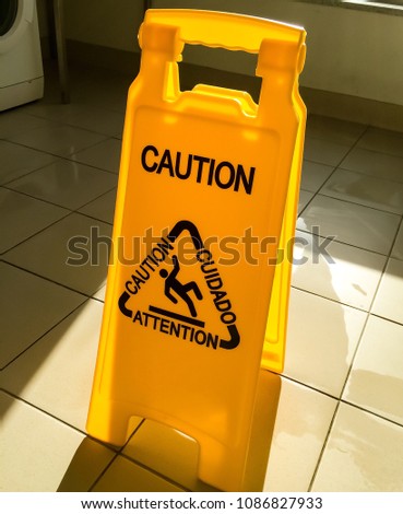 Wet floor sign warning people passing by.