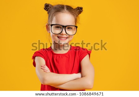 funny child girl wearing glasses on a colored background 
 Royalty-Free Stock Photo #1086849671