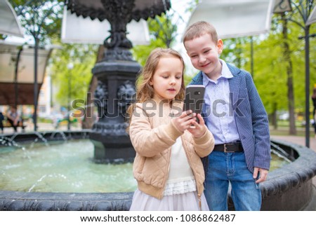 Two little kids taking selfie outdoor. Love friendship fun concept. Small adults