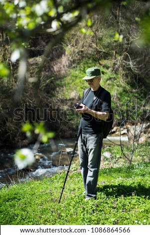 Senior man with his camera on a hiking trip