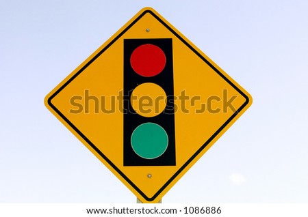 Street sign against a washed out sign indicates a traffic signal ahead.