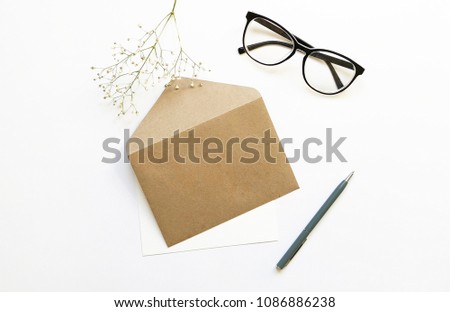 Flat lay stylish mockup photo with glasses, envelope, greeting card, gypsophila flowers and a pen. Feminine photo for blog and website.