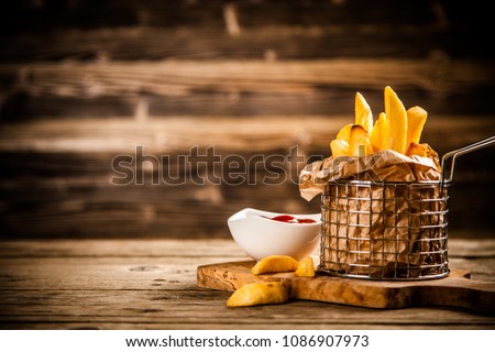 French fries on wooden table Royalty-Free Stock Photo #1086907973