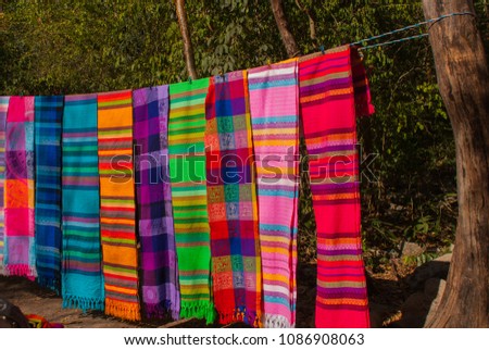 Souvenirs on the market. Multi-colored clothes. National clothes of Mexico. Multicolored textiles being representative for the latin america culture. Shawl of bright colorful