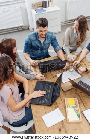 Team working over project with laptops on meeting in office
