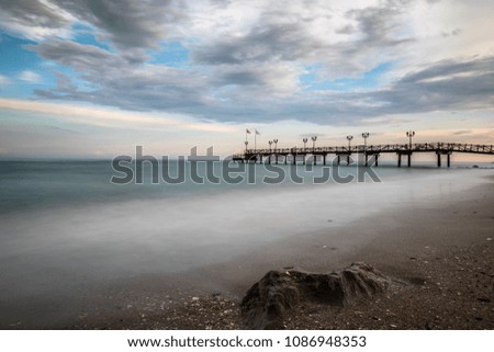 Long exposure of a beach in Marbella on the Costa del Sol in Spain taken at sunset with a dramatic sky on a cloudy day.