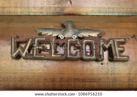 Sign welcome bolted on a wooden wall