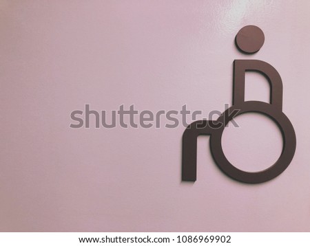 disabled person sign on the purple wall.
Toilet of disabled person sign.
