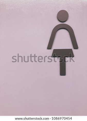 Lady Toilet sign on the purple wallpaper.
