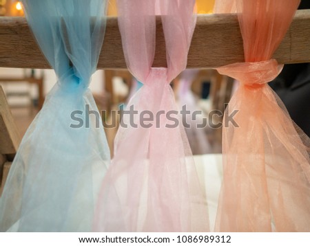 Pastel scarves tied in a knot for wedding chair decorations at a wedding venue
