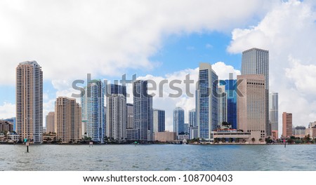 Miami skyline panorama in the day with urban skyscrapers and cloudy sky over sea