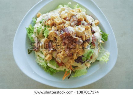 Fresh healthy Caesar salad on plate in top view picture style.