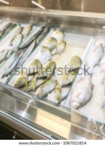 Blurred abstract variety of raw fresh fish chilling on bed of cold ice in seafood department of Asian market stall in USA