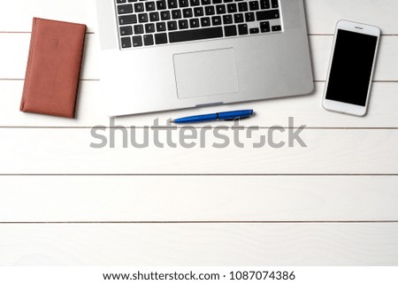 White wooden office desktop with laptop and business supplies. Top view