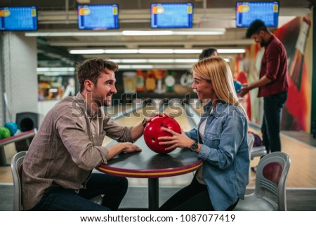 Shot of a young attractive couple talking in the bowling club