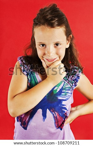 Picture of a funny little girl. Isolated on a red background