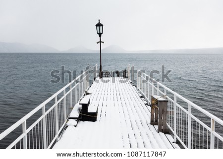 abandoned pier station on the cloudy deep blue lake with mountain in background