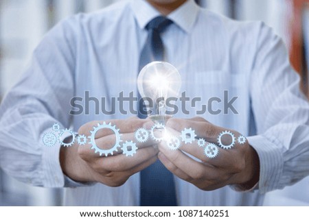Concept generation of ideas. Light stays on in the hand of the businessman with the help of machinery.
