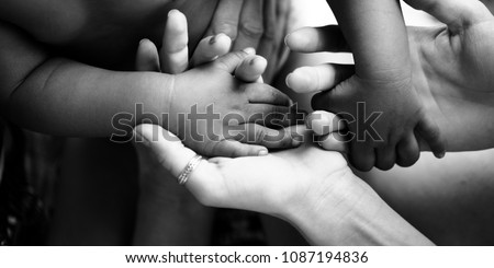 Touching moment, touch of the hand of a small child and an adult woman. Mother and child, adoptive children, adoption. A white woman and a dark skinned child. Interracial relations, multiracial family Royalty-Free Stock Photo #1087194836