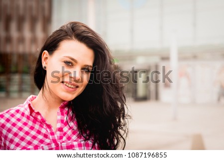 Portrait of a smiling and satisfied woman Isolated on a white background. A young and attractive girl looks ahead against the background of the shopping center. Retro style.