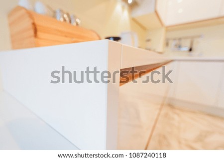 Modern kitchen white furniture with a table top made of natural stone. Advertising photography of kitchen interior. View of kitchen top corner